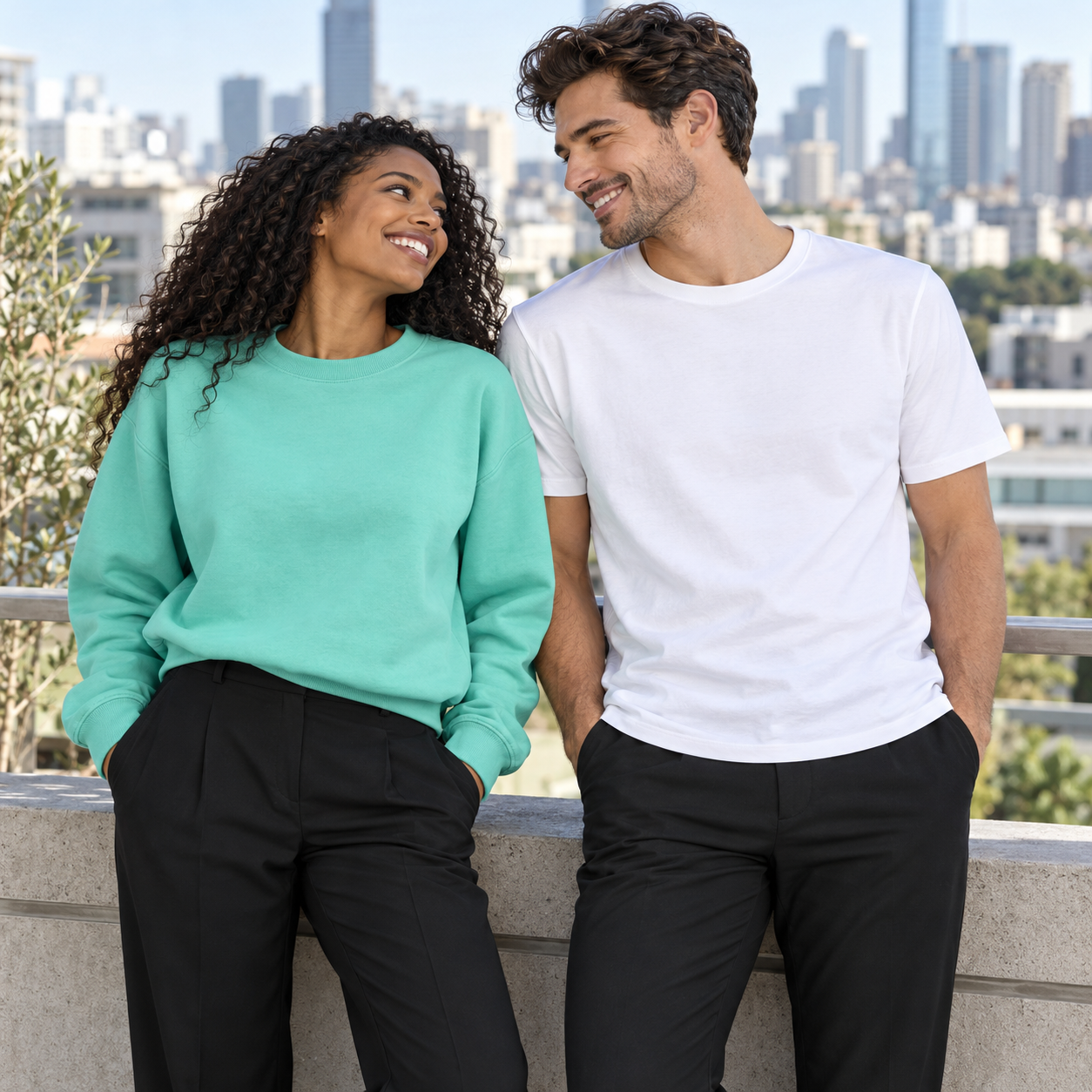 A Black woman and white man together in mint and white Manifesting apparel on a city terrace